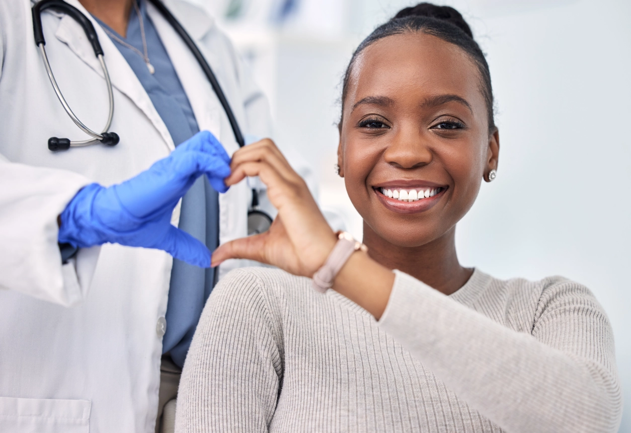 Doctor and patient making heart shape.