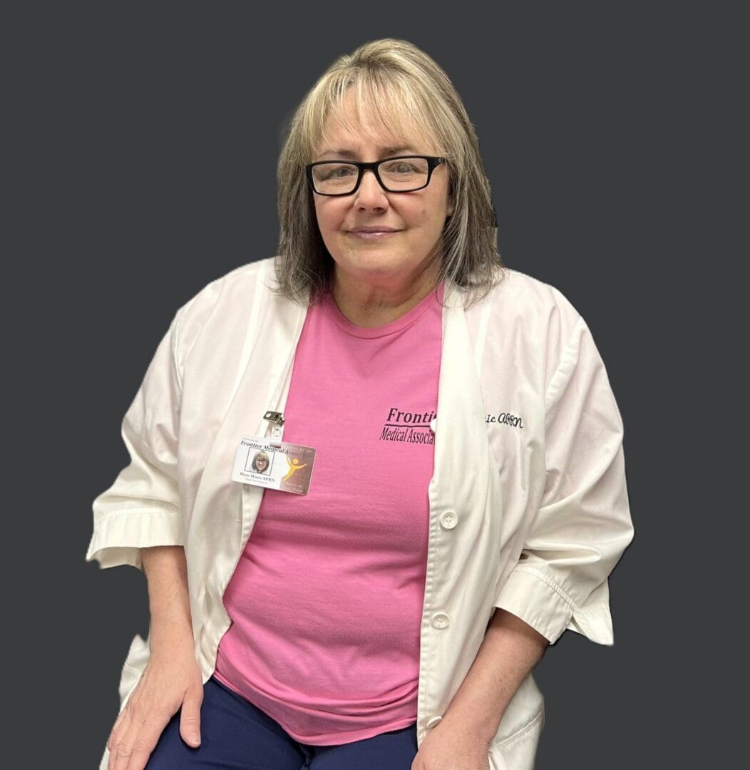Person wearing lab coat, pink shirt, ID badge