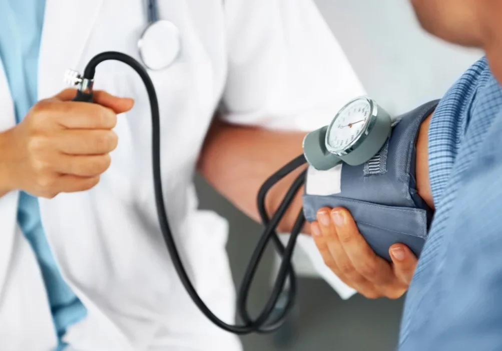 Doctor checking patient's blood pressure.