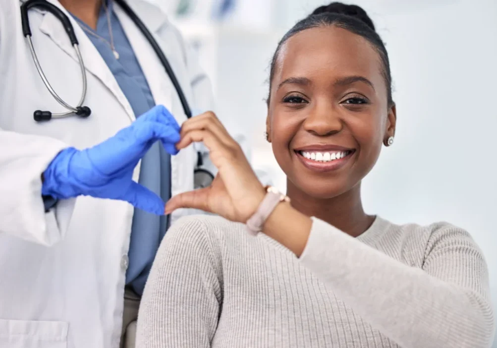 Doctor and patient making heart shape.